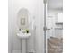 Powder room features pedestal sink, oval mirror, and stylish decor elements at 8024 Kennesaw Dr, Gastonia, NC 28056