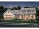 Elegant farmhouse exterior at night with metal roof and attached garage at 1012 Rosewood Dr # 14, China Grove, NC 28023