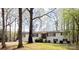 Charming white brick home with black shutters and a cozy front porch nestled among mature trees at 1035 Timberlane Dr, Lincolnton, NC 28092