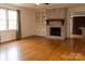 Cozy living room featuring a brick fireplace, hardwood floors, and built-in shelving for an inviting space at 1035 Timberlane Dr, Lincolnton, NC 28092