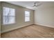 Bright bedroom with two windows, ceiling fan, and light wood flooring at 105 Fleishhacker Pl, Mooresville, NC 28117