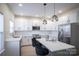 Modern kitchen with white cabinets, quartz countertops, and stainless steel appliances at 105 Fleishhacker Pl, Mooresville, NC 28117