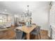 Bright dining room features a wood table with gray chairs, hardwood floors and an open concept to the kitchen at 1244 Heather Ln, Charlotte, NC 28209