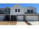 Charming townhome featuring a modern white and gray exterior with a one car garage and a well-maintained lawn at 1604 Village Grove Ln, Monroe, NC 28110