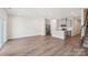 Spacious open-concept living area with wood-style flooring, kitchen, and staircase at 1604 Village Grove Ln, Monroe, NC 28110