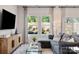 Spacious living room with large windows, gray sectional sofa, and wood-look floors at 1604 Village Grove Ln, Monroe, NC 28110