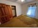 Simple bedroom with wood closet doors and window at 319 N Peterson St, Stanley, NC 28164