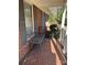 Brick front porch with a quaint bench and tile flooring at 319 N Peterson St, Stanley, NC 28164