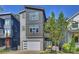 Modern three-story home with gray siding, white garage door, and blue front door at 416 Wesley Heights Way, Charlotte, NC 28208