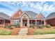 Charming brick home featuring stone accents, covered porch, landscaped front yard, and a welcoming entrance at 535 Chalmers Row, Rock Hill, SC 29732