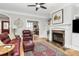 Comfortable living room with hardwood floors, a ceiling fan, a fireplace, and a leather sofa at 535 Chalmers Row, Rock Hill, SC 29732
