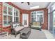 Inviting sunroom with brick walls, skylight, ceiling fan, large windows with shutters, and comfortable wicker furniture at 535 Chalmers Row, Rock Hill, SC 29732