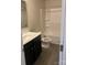 Clean bathroom with dark vanity, shower/tub combo, and gray vinyl flooring at 104 Springdale St, Shelby, NC 28150