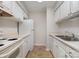 Galley kitchen featuring white cabinets, appliances, and vinyl flooring at 133 Orchard Trace Ln # 7, Charlotte, NC 28213