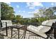 Small balcony with chairs and side table, overlooking trees at 330 Simeon Dr, Charlotte, NC 28208