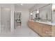 Bright bathroom featuring double vanity with modern fixtures, marble floors, and a view into the bedroom at 3415 Waxhaw Indian Trail S Rd, Waxhaw, NC 28173
