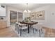 Modern dining area features a dark wood table, modern chandelier, and access to the outdoor living space at 3415 Waxhaw Indian Trail S Rd, Waxhaw, NC 28173