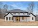 Back exterior showcasing a white two-story home with a covered porch supported by wooden beams at 3415 Waxhaw Indian Trail S Rd, Waxhaw, NC 28173