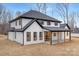Rear exterior of a two-story home with white siding, black trim, and a covered patio at 3415 Waxhaw Indian Trail S Rd, Waxhaw, NC 28173