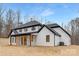 Rear exterior view of a white brick home with black trim and a covered porch at 3415 Waxhaw Indian Trail S Rd, Waxhaw, NC 28173