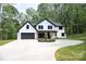 Beautiful two-story home with a black-trimmed roof, black garage door, circle drive, and fresh landscaping at 3415 Waxhaw Indian Trail S Rd, Waxhaw, NC 28173