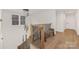 Hallway with wood floors, wood railing with iron balusters, modern chandelier and bench at 3415 Waxhaw Indian Trail S Rd, Waxhaw, NC 28173