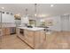Spacious kitchen island with white countertop, a microwave, and a view of the dining area and living spaces at 3415 Waxhaw Indian Trail S Rd, Waxhaw, NC 28173