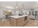 Gourmet kitchen island with white countertops, seating, and a view of the dining and living spaces at 3415 Waxhaw Indian Trail S Rd, Waxhaw, NC 28173