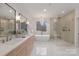 Luxurious main bathroom with dual vanity, soaking tub, and glass-enclosed shower at 3415 Waxhaw Indian Trail S Rd, Waxhaw, NC 28173