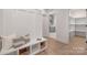 Open mudroom with white paneled walls, bench seating, storage baskets, and access to the pantry at 3415 Waxhaw Indian Trail S Rd, Waxhaw, NC 28173