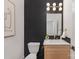 Chic powder room with black tile accent wall, modern vanity, and stylish fixtures at 3415 Waxhaw Indian Trail S Rd, Waxhaw, NC 28173