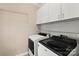 Modern laundry room featuring a front-load washer and dryer with overhead shelving and cabinets at 430 43Rd Nw Ave, Hickory, NC 28601