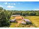 Sprawling horse property with multiple barns, training rings, pastures, and wooded areas under a bright blue sky at 795 French Belk Rd, Mt Ulla, NC 28125