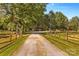 Gravel driveway lined with split rail fencing leading to various structures and pastures at 795 French Belk Rd, Mt Ulla, NC 28125