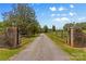 Welcoming gated entrance leading to a tree-lined driveway at 795 French Belk Rd, Mt Ulla, NC 28125