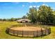 Horse training area with a sandy paddock and stables in the background under a sunny, blue sky at 795 French Belk Rd, Mt Ulla, NC 28125