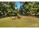 Beautiful aerial view of paddock with grazing horses, framed by lush trees and a rustic wooden fence at 795 French Belk Rd, Mt Ulla, NC 28125