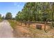 Rustic paddock features a wooden fence and mature trees, providing a serene country setting at 795 French Belk Rd, Mt Ulla, NC 28125