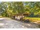 Open-sided barn used for storing vehicles, trailers, and an ATV on a wooded property at 795 French Belk Rd, Mt Ulla, NC 28125