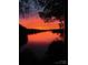 A fiery sunset reflected over a tranquil lake, framed by silhouetted trees at 990 19Th Nw Ave, Hickory, NC 28601