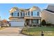 Two-story house with a large front yard, two-car garage, and neutral-colored siding at 112 Artisan Ct, Mooresville, NC 28117