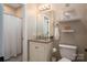Well-lit bathroom with a granite vanity, toilet, and tiled shower with a curtain and niche at 1370 Null Rd, Lincolnton, NC 28092