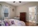 Cozy bedroom with a floral comforter, wood floors, large window, chest of drawers and ensuite bathroom at 1370 Null Rd, Lincolnton, NC 28092