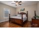 Bedroom features hardwood floors, a ceiling fan, a large window, and a traditional wood bed frame at 1370 Null Rd, Lincolnton, NC 28092