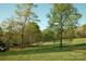 Expansive green field surrounded by mature trees on a sunny day at 1370 Null Rd, Lincolnton, NC 28092