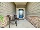 Inviting front porch with stone accents and two wicker chairs at 15618 Aviary Orchard Way, Charlotte, NC 28278