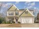 Two-story house with beige and green siding, a purple door, and a two-car garage at 217 Stowe Creek Ln, Mount Holly, NC 28120