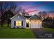 Newly built home with gray siding, white garage door, and landscaped lawn at 5517 Skycrest Dr, Charlotte, NC 28269