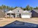 Gray house with white trim, three-car garage, and a manicured lawn at 8825 Chapel Grove Crossing Dr, Huntersville, NC 28078