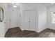 Bright entryway with dark wood floors, coat closet, and mirror at 11058 Argosy Dr, Lancaster, SC 29720